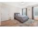 Bright bedroom featuring a grey bed, neutral walls, and wood-look floors, with a bedside table at 2928 Parkwest Dr, Albemarle, NC 28001