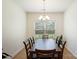 Bright dining room featuring modern chandelier, wood table set, and window overlooking the green outdoors at 2928 Parkwest Dr, Albemarle, NC 28001