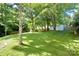 Spacious backyard featuring a lush lawn, mature trees, and a storage shed, perfect for outdoor activities at 3549 Woodleaf Rd, Charlotte, NC 28205