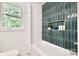 Well-lit bathroom featuring a bathtub with stylish tile surround and a convenient built-in niche at 3549 Woodleaf Rd, Charlotte, NC 28205