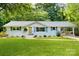 Charming single-story home with a well-manicured lawn, white brick, and a welcoming yellow front door at 3549 Woodleaf Rd, Charlotte, NC 28205