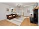 Spacious living room featuring a black brick fireplace, hardwood floors, and comfortable seating at 3549 Woodleaf Rd, Charlotte, NC 28205