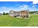 Expansive backyard with a covered patio, outdoor grill area, and a well-manicured lawn at 3645 Kimber Ln, Sherrills Ford, NC 28673