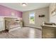 Charming Bedroom with grey wooden floors, a crib, and a window overlooking the outdoors at 3645 Kimber Ln, Sherrills Ford, NC 28673