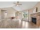 This living room has wood-look floors, a fan, a brick fireplace, and a doorway to the bathroom at 3645 Kimber Ln, Sherrills Ford, NC 28673