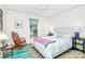 Comfortable bedroom with a white wicker bed frame, rocking chair, ceiling fan, and ample natural light at 3708 Sweetgrass Ln, Charlotte, NC 28226