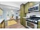 Bright kitchen featuring stainless steel appliances and olive-green cabinets with a dining area at 3708 Sweetgrass Ln, Charlotte, NC 28226
