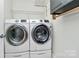 Well-lit laundry room showcasing modern white washer and dryer with storage and shelving at 3708 Sweetgrass Ln, Charlotte, NC 28226