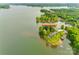 An aerial shot displays waterfront estate at 3911 Sandy Point Rd surrounded by trees with a private dock at 3911 Sandy Point Dr, York, SC 29745