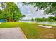 Grassy backyard featuring a lakeside view with a private dock, fire pit and areas ready for relaxation at 3911 Sandy Point Dr, York, SC 29745