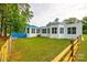 Spacious backyard with a blue deck, manicured lawn, and a white exterior home on a sunny day at 3911 Sandy Point Dr, York, SC 29745