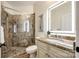 Elegant bathroom with granite vanity, illuminated mirror, and luxurious glass-enclosed stone shower at 3911 Sandy Point Dr, York, SC 29745