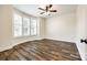 Sunlit bedroom featuring bay windows with wooden shutters, a ceiling fan, and hardwood floors at 3911 Sandy Point Dr, York, SC 29745