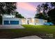 Charming single-story home featuring a blue garage door, well-manicured lawn, and modern design elements at 3911 Sandy Point Dr, York, SC 29745