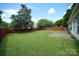 Serene backyard with a lush lawn, mature trees, and privacy fence offers a peaceful outdoor retreat at 4037 Lakota Ct, Charlotte, NC 28269