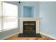 Close up of fireplace surrounded by built-in cubby, window, and hardwood floors at 4037 Lakota Ct, Charlotte, NC 28269