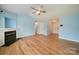 Spacious living room featuring a fireplace, ceiling fan, hardwood floors, and access to entry at 4037 Lakota Ct, Charlotte, NC 28269