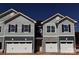 New townhome exterior featuring gray siding, stone accents, black shutters, and a two-car garage at 4041 Port Richmond Ave # 9, Gastonia, NC 28056
