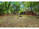 Landscaped backyard with a wooden fence and fire pit, ideal for outdoor entertaining at 4114 Stacy Blvd, Charlotte, NC 28209