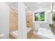 Bathroom with tiled shower-tub combination, vanity and a window at 4114 Stacy Blvd, Charlotte, NC 28209