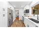 Galley kitchen with modern stainless steel appliances, wood floor and bright white cabinets and countertops at 4114 Stacy Blvd, Charlotte, NC 28209