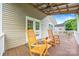 Inviting back porch featuring two rocking chairs and a ceiling fan for relaxing outdoor living at 4569 Edgeland Rd, Edgemoor, SC 29712