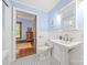 Charming bathroom with classic black and white tiled floor and a pedestal sink, leading into the light-filled main bedroom at 4569 Edgeland Rd, Edgemoor, SC 29712