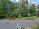Inviting front entrance featuring a gravel driveway and charming landscape elements at 490 Deberry Rd, Mount Gilead, NC 27306