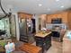 Well-lit kitchen with stainless steel appliances, wooden cabinets, a central island, and an adjacent dining area at 490 Deberry Rd, Mount Gilead, NC 27306