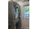 Practical laundry area with stacked washer and dryer, a door with natural light and simple decor at 490 Deberry Rd, Mount Gilead, NC 27306