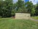 Side view of a storage building on green grass with a small chicken coup in the back at 490 Deberry Rd, Mount Gilead, NC 27306