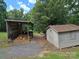 Two sheds on a well-maintained yard with greenery and gravel driveway at 490 Deberry Rd, Mount Gilead, NC 27306