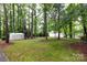 Secluded backyard with mature trees, grass and a storage shed at 509 Selkirk Pl, Charlotte, NC 28270