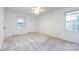 A simple, bright bedroom space awaits with neutral walls and carpet, illuminated by natural light from two windows at 509 Selkirk Pl, Charlotte, NC 28270