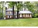 Charming two-story home featuring brick and gray siding, surrounded by lush greenery and mature trees at 509 Selkirk Pl, Charlotte, NC 28270