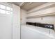 Functional laundry room with washer, dryer, utility sink, shelving, and exterior door at 509 Selkirk Pl, Charlotte, NC 28270