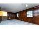 Cozy living area with wood paneling, a brick fireplace, and stairs leading to another level at 509 Selkirk Pl, Charlotte, NC 28270