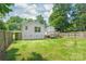 Backyard with a privacy fence, featuring green grass and mature shade trees surrounding the property at 518 Westside Cir, China Grove, NC 28023