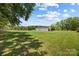 A lush green yard featuring outbuildings and mature trees at 5200 Winding Ln, Indian Trail, NC 28079