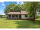 Charming front exterior featuring a covered porch and well-maintained yard with mature trees at 5200 Winding Ln, Indian Trail, NC 28079