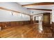 Open living room with exposed wood beams, hardwood floors, and view to the entry at 5200 Winding Ln, Indian Trail, NC 28079