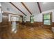 Bright living room with hardwood floors, exposed beams, and large windows with natural light at 5200 Winding Ln, Indian Trail, NC 28079