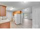 Bright kitchen featuring light wood cabinets, white appliances, and an open view to the adjacent living area at 6216 Bandy Dr, Charlotte, NC 28227