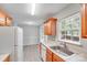Bright kitchen featuring wood cabinets, stainless steel sink, white appliances, and natural light at 6216 Bandy Dr, Charlotte, NC 28227