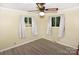 Cozy bedroom with two windows, light walls, wood-look floors, and a ceiling fan at 709 Sunset Dr, Salisbury, NC 28147