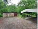 Gravel driveway with wooden storage shed and a covered picnic area in the back at 709 Sunset Dr, Salisbury, NC 28147