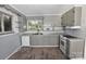 Well-lit kitchen features gray cabinets, a dual basin sink, and white appliances at 709 Sunset Dr, Salisbury, NC 28147