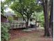 View of the rear of the home with a wooden deck, air conditioner and tall trees at 709 Sunset Dr, Salisbury, NC 28147