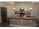 Bright kitchen featuring white cabinets, stainless steel appliances, granite countertops, and a kitchen island with a sink at 813 Latrobe Dr # 365, Iron Station, NC 28080