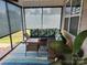 Inviting screened porch with comfortable seating, wicker table, and bright, colorful rug at 813 Latrobe Dr # 365, Iron Station, NC 28080